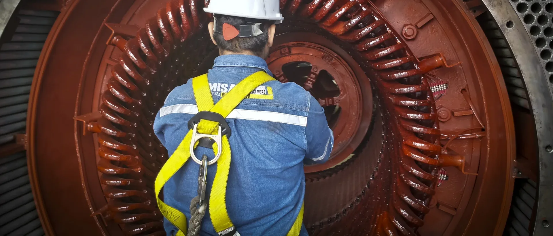 Técnico de TEMISA inspeccionando el rotor de polos salientes de un generador síncrono en el taller